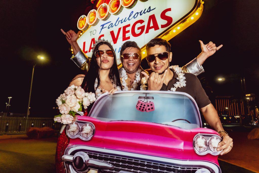 Couple with Elvis in pink Cadillac at Las Vegas Sign vow renewal