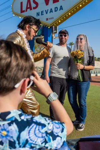 Photographer captures a candid moment as bride and groom share a laugh during their Las Vegas sign wedding.